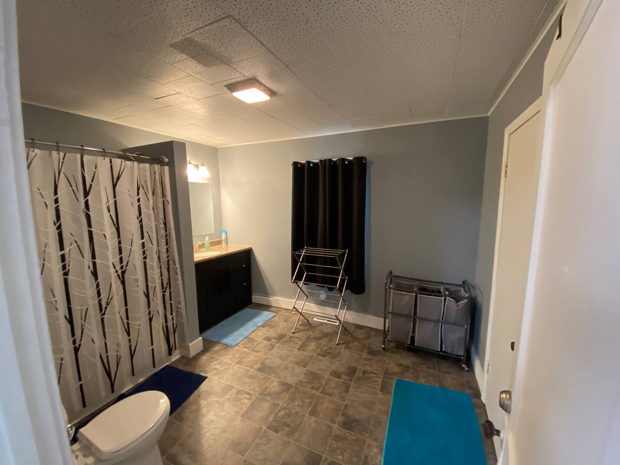 A large bathroom with a shower, sink, and toilet.