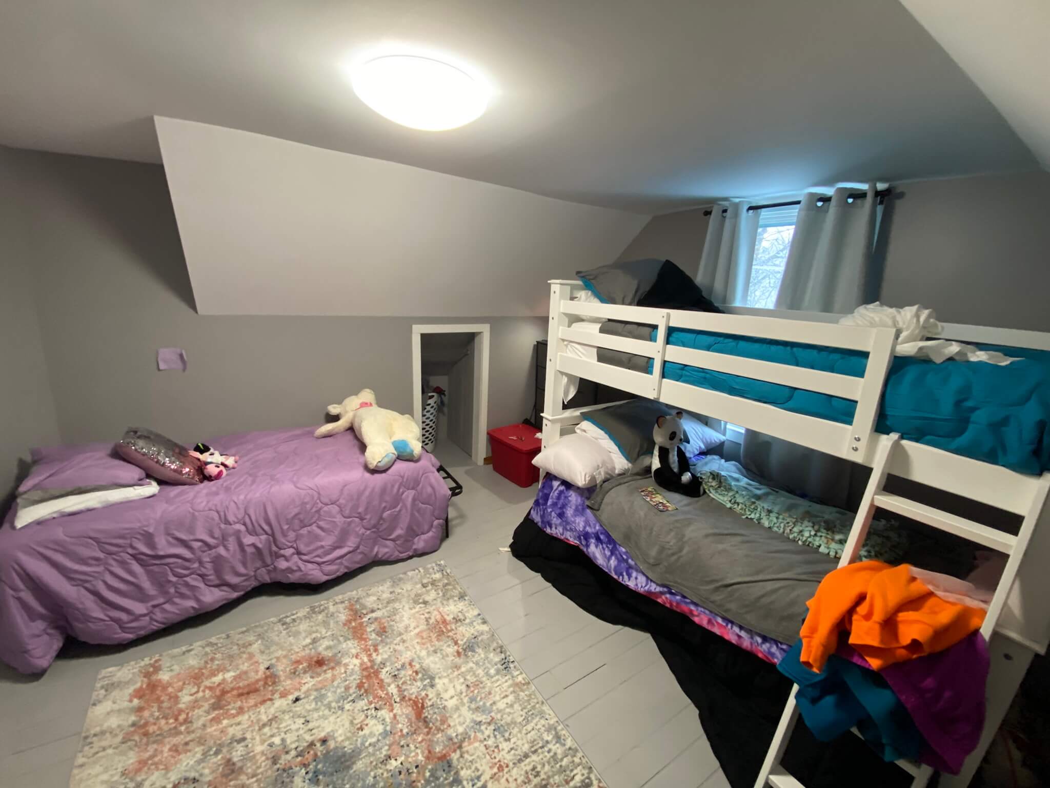 A bedroom with a bunk bed and a third bed next to it